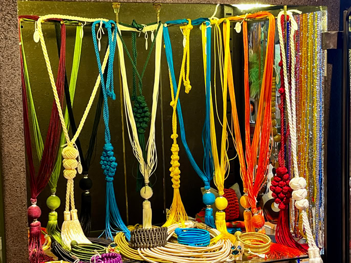 Des colliers colorés suspendus dans une vitrine.