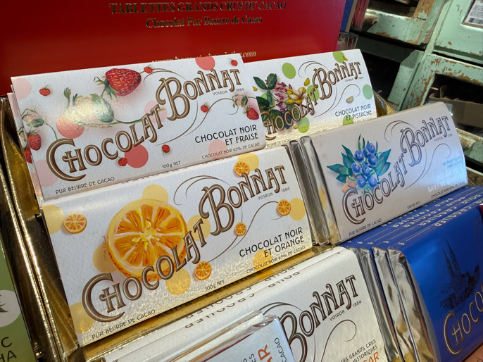 Tablettes de chocolat colorées de la marque "Chocolat Bonnat" avec des illustrations de fruits et de fleurs sur les emballages.