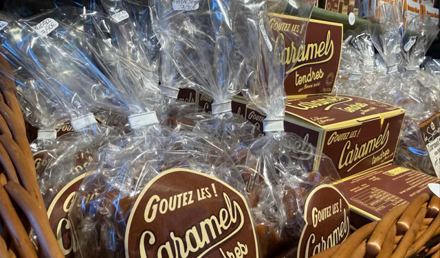Des sacs et boîtes de caramels emballés dans un panier en osier.