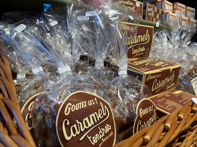 Sachets et boîtes de caramels emballés dans un panier en osier.