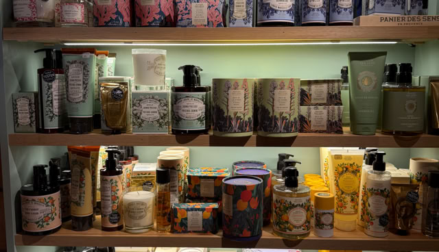 Étagère avec divers produits de soins et cosmétiques, incluant des bouteilles et des boîtes colorées.