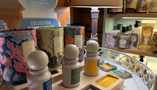 Produits de soins sur une étagère, comprenant des bouteilles et des boîtes colorées, avec une lampe allumée à l'arrière-plan.