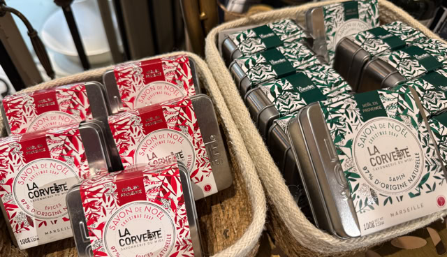 Deux paniers contenant des boîtes de chocolat, l'un avec des emballages rouges et l'autre avec des emballages verts, posés sur une table en bois.
